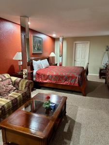 a hotel room with a bed and a coffee table at Western Plaza Inn in De Queen