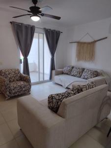 ein Wohnzimmer mit Sofa und Deckenventilator in der Unterkunft Hermosa Villa con recamara en PB in Acapulco