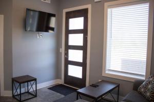 a living room with a door with a television and a couch at Music City Condo Near Downtown in Nashville +4 photos