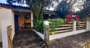 a fence in front of a house with flowers at Casa da praia, Caraguatatuba in Caraguatatuba