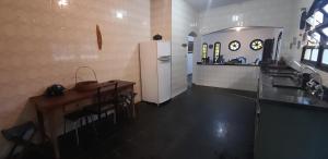 a kitchen with a white refrigerator and a table at Casa da praia, Caraguatatuba in Caraguatatuba +11 photos