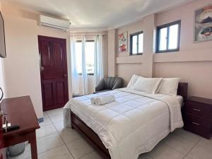Un dormitorio con una cama y una silla dentro. en Hotel Terraza Zoe, en Managua