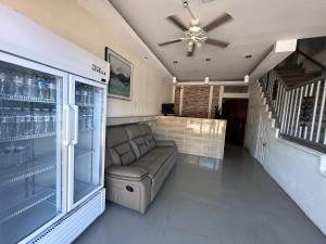 Una sala de estar con un sofá y un ventilador de techo. en Hotel Terraza Zoe, en Managua