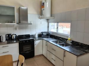 a kitchen with a sink and a stove at Rooftop Velez Sarsfield in Buenos Aires +18 photos