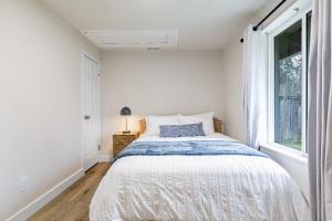 a white bedroom with a bed and a window at Dog Friendly Cozy Remodeled Shoreline Rambler in Shoreline