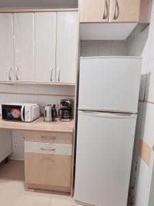 kuchnia z białą lodówką i białymi szafkami w obiekcie Hostel Las Rosas w Madrycie +34 zdjęcia