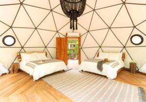 two beds in a room with a geometric wall at Amaite Retreat Tulúm in Macario Gomez