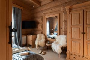 a bedroom with a mirror and two chairs and a desk at Willa Rajka in Zakopane