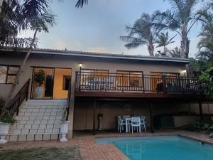 a house with a balcony and a swimming pool at Ascott Manor in Scottburgh