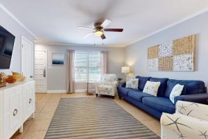 a living room with a blue couch and a ceiling fan at Southern Sunsets in Destin