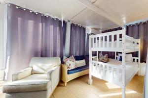 a bedroom with a white bunk bed and a couch at Southern Sunsets in Destin