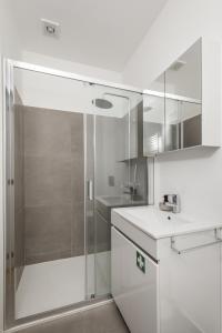 un bagno bianco con doccia e lavandino di Douro's Bridge View - Swimming pool a Vila Nova de Gaia