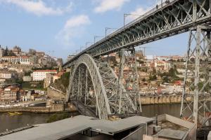 un grande ponte di metallo sopra un fiume con una città di Douro's Bridge View - Swimming pool a Vila Nova de Gaia