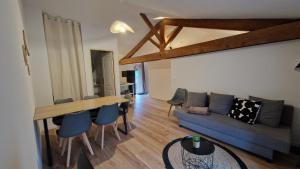 a living room with a couch and a table and chairs at Le Bourg in Lagnieu