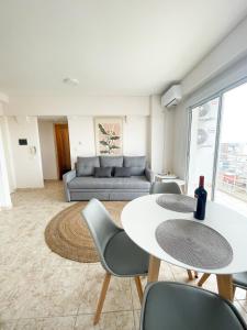 a living room with a couch and a table and chairs at Saavedra 118 8F by depptö in Bahía Blanca
