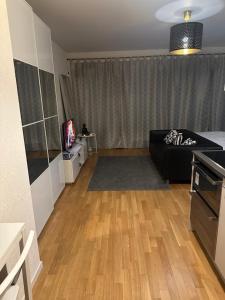 a living room with a black couch and a tv at Apartamento Ginebra ch in Geneva