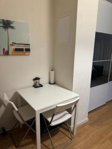 a white table with two chairs and a candle on it at Apartamento Ginebra ch in Geneva