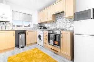 a kitchen with wooden cabinets and white appliances at Middle Meadow 2 bedroom Modern Apartment Sleeps 3 Contractors Families in Tipton