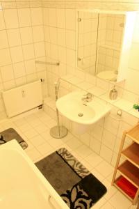 a white bathroom with a sink and a mirror at Ferienwohnung Hoff in Göllingen