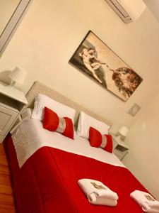 a bedroom with a bed with red and white pillows at Cuore di Roma Apartment in Rome