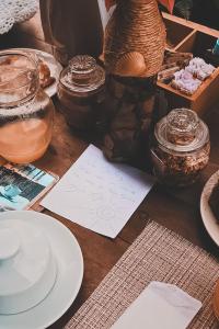 a table with plates and jars and a piece of paper at Junduh Brasil Pousada e Restaurante in Icaraí +25 photos