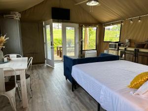 a bedroom with a bed and a table and a kitchen at Piney River Resort in Bon Aqua +102 photos