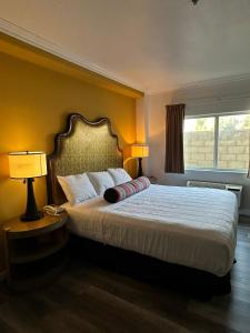 a bedroom with a bed with two lamps and a window at Howard Johnson by Wyndham Bakersfield in Bakersfield +11 photos