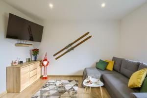 ティリチにあるApartamenty Tylicka Ostojaのソファとテレビのあるリビングルーム