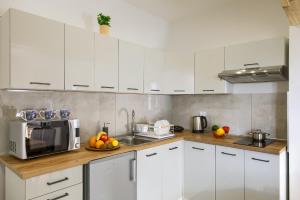 ティリチにあるApartamenty Tylicka Ostojaの白いキャビネットと電子レンジを備えたキッチン