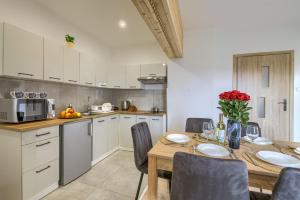 ティリチにあるApartamenty Tylicka Ostojaのキッチン(テーブル、椅子、電子レンジ付)