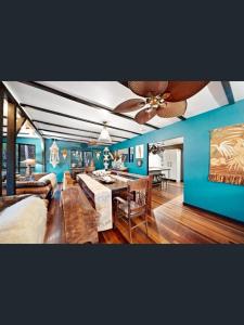a living room with blue walls and a ceiling fan at Rakali Retreat in Cooran
