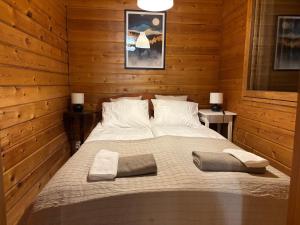 a bedroom with a large bed in a wooden room at Villa Oitola I Parking I Sauna I Wifi I Lake I Rural I Forest I Ideal for Aurora spotting in Sonka