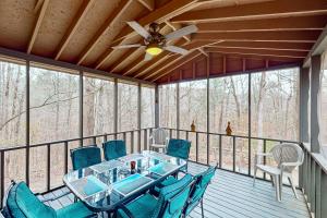 a screened in porch with a table and chairs at Four Seasons Retreat in Townsend