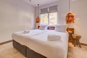 a bedroom with a large white bed with towels on it at La Boheme - Adults Only in Obzor