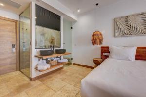 a bedroom with a bed and a bathroom with a sink at La Boheme - Adults Only in Obzor