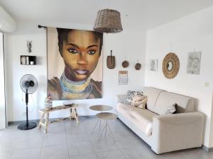 a living room with a large painting of a woman at Appartement Shenandoah in Sainte-Anne