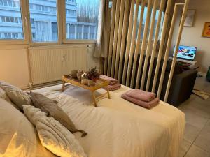 una camera da letto con un grande letto con un tavolo sopra di LeRelaisdOdile - Studio Cosy - Proche Metro - Parking Gratuit - Mons-en-Barœul a Mons-en-Baroeul