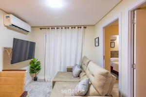 Apto 2Qtos centro BC a 160m da praia SRL002 في باليريو كامبوريو: غرفة معيشة مع أريكة وتلفزيون +4 صور