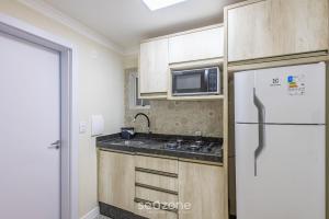 Apto 2Qtos centro BC a 160m da praia SRL002 في باليريو كامبوريو: مطبخ مع ثلاجة بيضاء وميكروويف