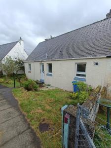 洛哈尔什教区凯尔高地2 bed highland home base for Isle of Skye and Lochalsh的一栋前面有栅栏的白色房子