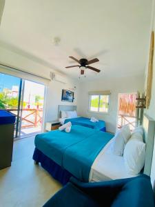 a bedroom with two beds and a ceiling fan at Casa Coronaa Holbox México in Holbox Island