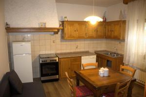a kitchen with a wooden table and a kitchen with a refrigerator at Lodge Pizzo Alpestre in Abetone