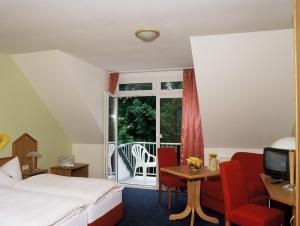a hotel room with a bed and a balcony at Hotel zur Post in Deudesfeld