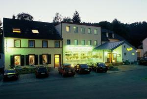 Hotel zur Post في Deudesfeld: مجموعة سيارات متوقفة أمام مبنى