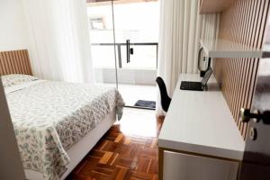 een slaapkamer met een bed, een bureau en een raam bij Casa Enorme com Piscina, Sauna e Área para Festas in Belo Horizonte