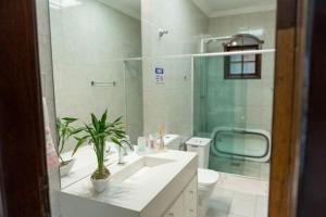 een witte badkamer met een wastafel en een toilet bij Casa Enorme com Piscina, Sauna e Área para Festas in Belo Horizonte +34 foto's