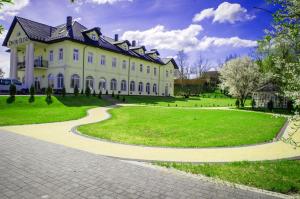 a large white house with a curved driveway at Dwór Olimp in Stalowa Wola