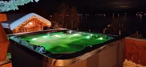 Whirlpool-Badewanne mit schneebedecktem Haus in der Unterkunft Malangen Lodge in Mestervik