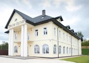 Un gran edificio blanco con un cartel en él. en Dwór Olimp, en Stalowa Wola