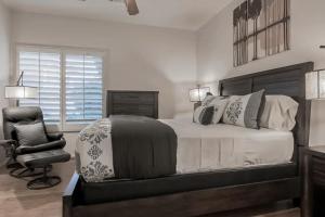 une chambre avec un grand lit et une chaise dans l'établissement Desert Escape, à La Quinta